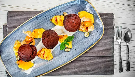 3 Brownies mit gebacknere Ananas schön angerichtet auf Teller