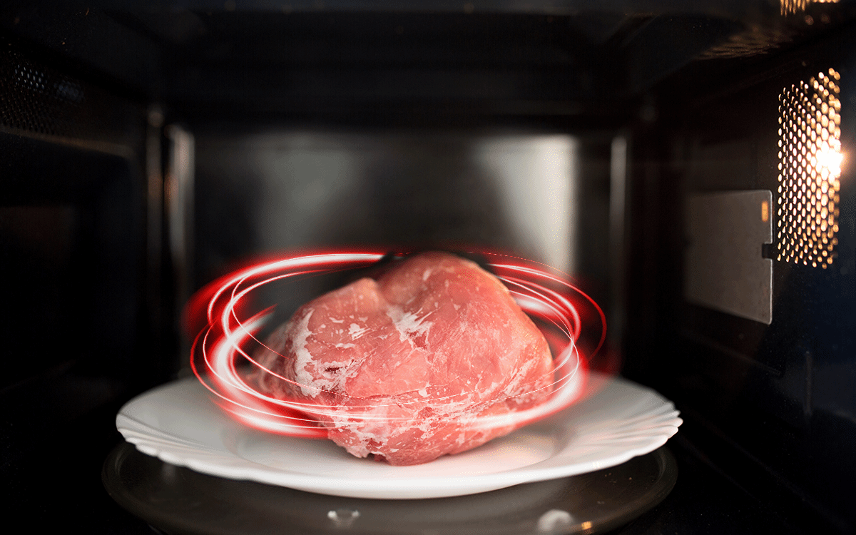 Mikrofalówka Toshiba rozmrażająca kawałek mięsa na talerzu